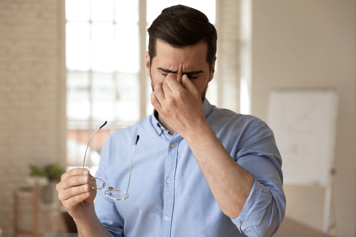 a man holding a hand to his face in discomfort