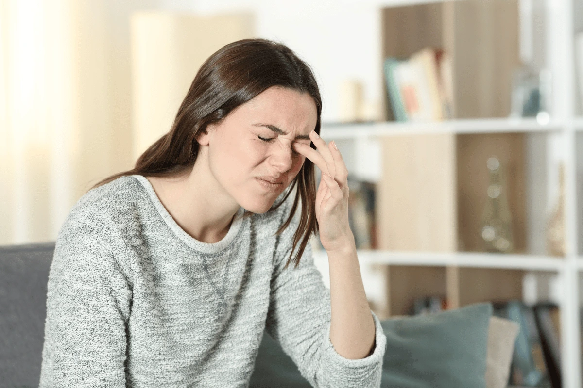 a woman rubbing her eye due to dry eyes