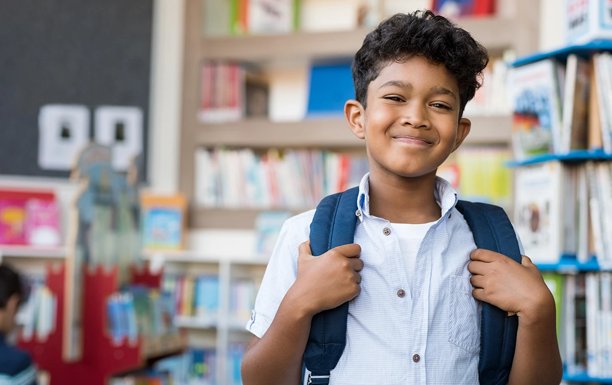 a young boy smiling at school
